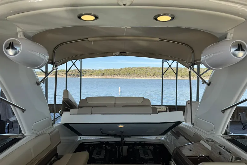 Slide: The Image of 2018 Formula 310 Bowrider interior with open engine hatch, overlooking serene lake view. - 31