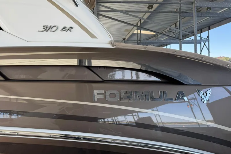 Slide: The Image of 2018 Formula 310 Bowrider boat, close-up of logo and model name under a metal canopy. - 4
