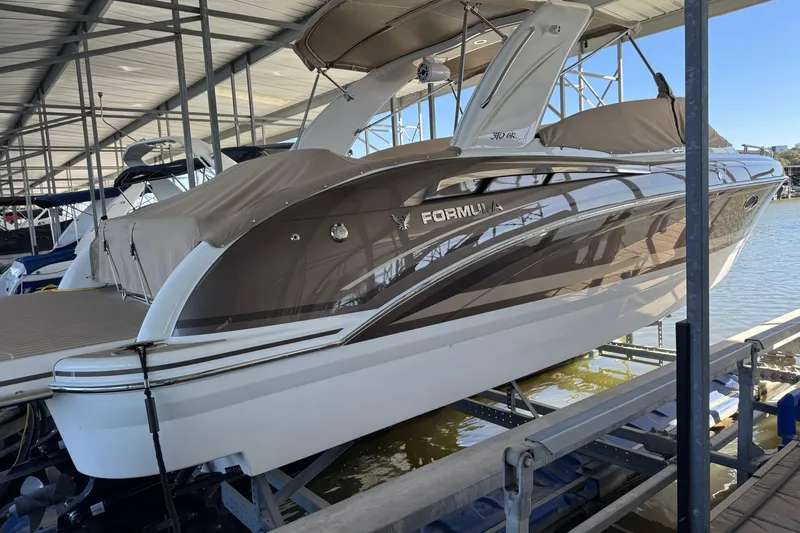 Slide: The Image of 2018 Formula 310 Bowrider boat docked in a marina under a covered structure. - 8