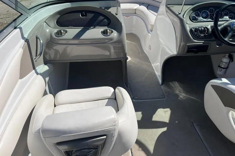 Slide: The Image of Interior of a 2010 Crownline 210 LS boat with white seating and dashboard controls. - 10