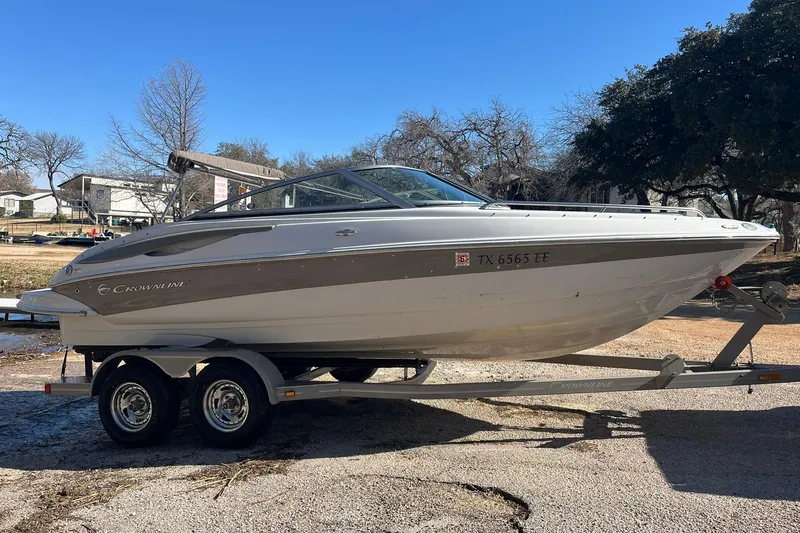 Slide: The Image of 2010 Crownline 210 LS boat on trailer, parked outdoors on a sunny day. - 3