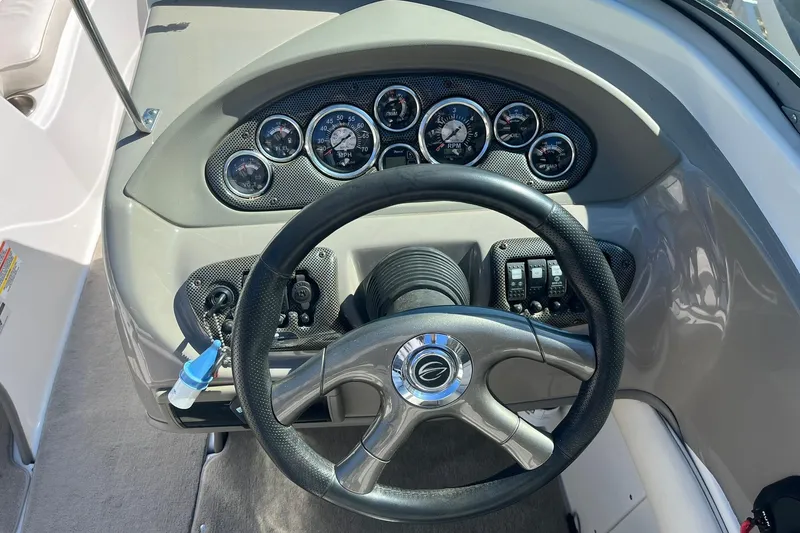 Slide: The Image of Steering wheel and dashboard of a 2010 Crownline 210 LS boat, featuring multiple gauges. - 8