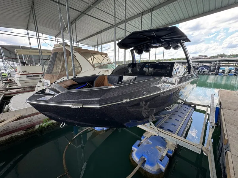 Slide: The Image of 2025 Tigé Ultré 25ZX boat in marina, sleek design. - 8