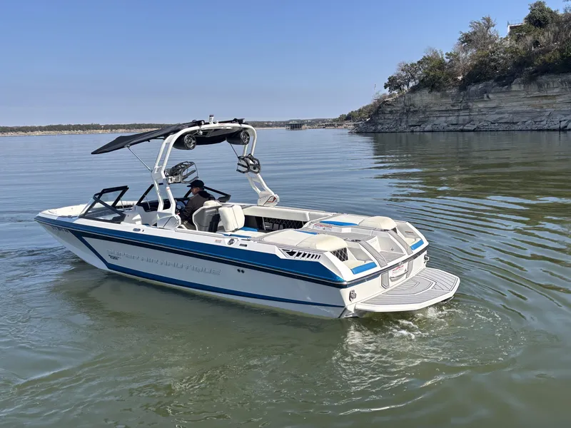 Slide: The Image of 2021 Nautique GS24 boat on calm lake with cliffs. - 3