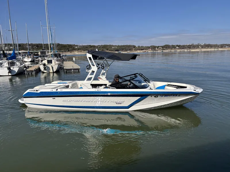 Slide: The Image of 2021 Nautique GS24 boat on calm water in harbor. - 5