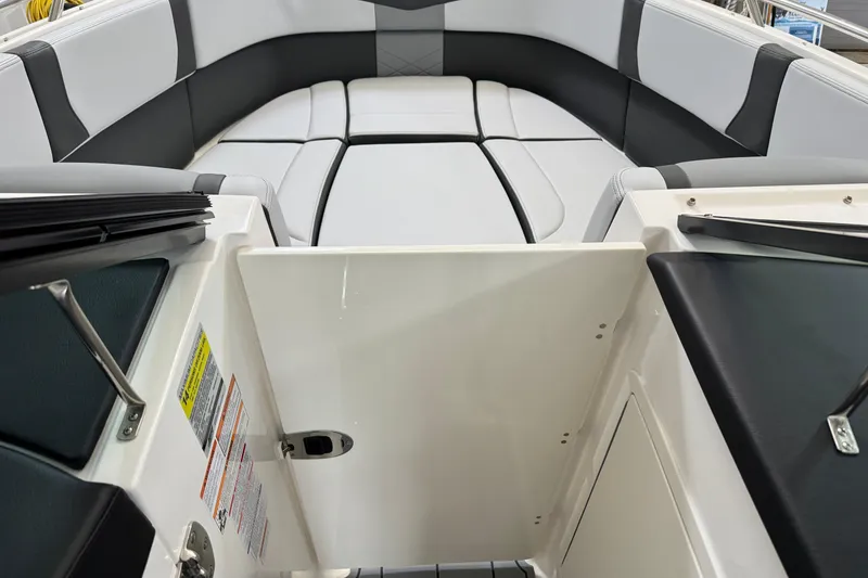 Slide: The Image of 2026 Chaparral 270 OSX boat interior with sleek seating and open storage compartment. - 33