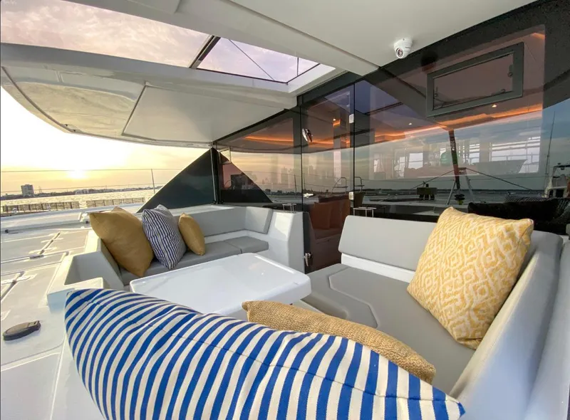 Slide: The Image of Luxurious Leopard 50 yacht interior with cushions, sunset in the background. - 10