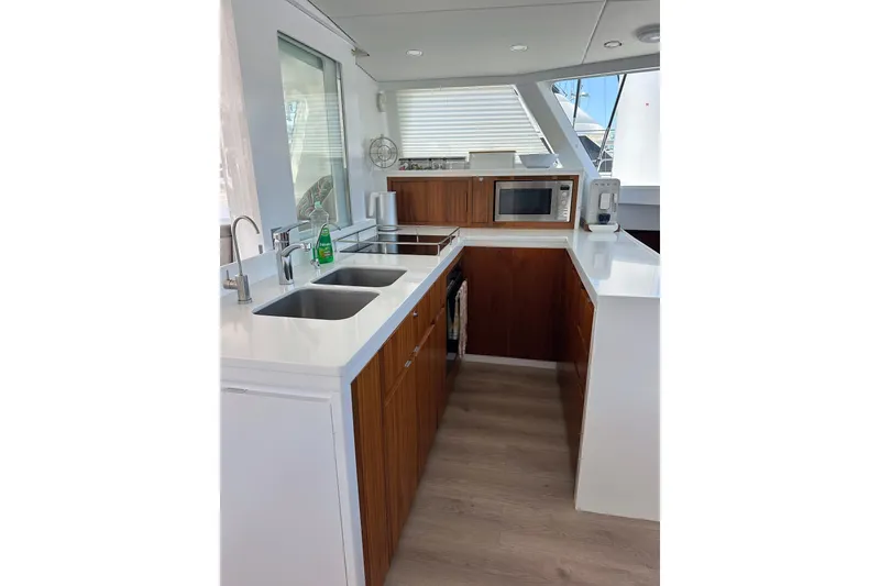 Slide: The Image of Modern yacht kitchen with wood cabinets, dual sinks, and appliances. Balance 526, 2022 model. - 11
