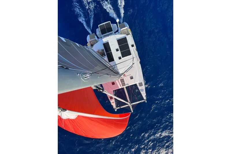 Slide: The Image of Aerial view of Balance 526 catamaran sailing with red sail on blue ocean, 2022 model. - 2