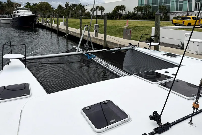 Slide: The Image of Catamaran Balance 526, 2022 model, docked at marina with netted deck and scenic waterfront. - 32