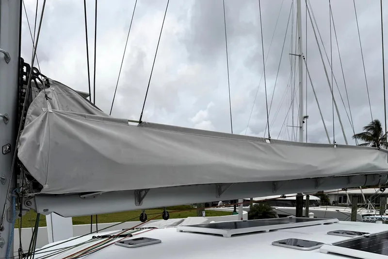 Slide: The Image of Sailboat mast and boom with sail cover, Balance 526, 2022 model, docked under cloudy sky. - 33