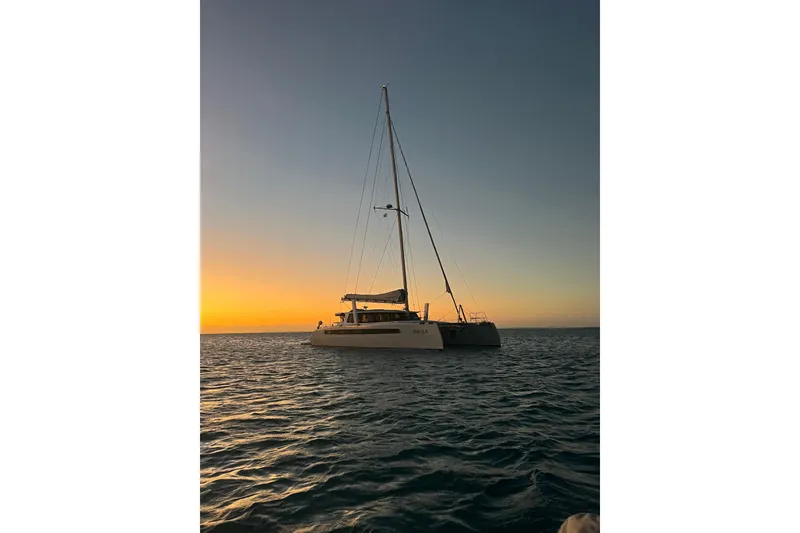 Slide: The Image of Sailing catamaran Balance 526 at sunset, 2022 model, on calm ocean waters. - 49