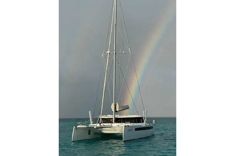 Slide: The Image of Sailing catamaran Balance 526, 2022 model, with rainbow in the background over turquoise sea. - 51