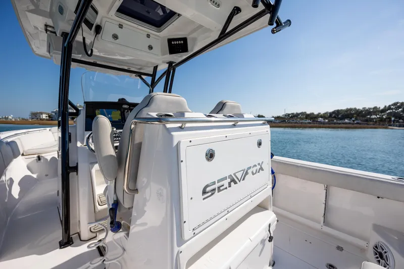 Slide: The Image of 2023 Sea Fox 288 Commander boat interior with helm and seating, on calm water. - 19
