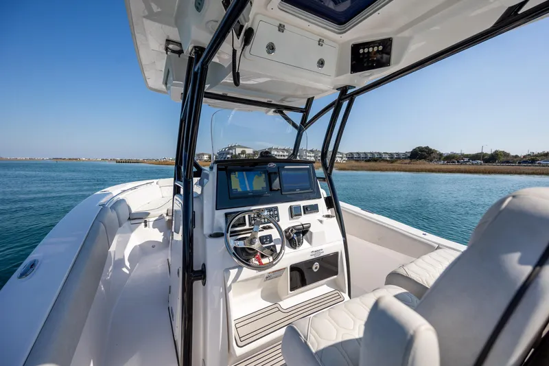 Slide: The Image of 2023 Sea Fox 288 Commander boat interior with modern helm and seating on calm water. - 22