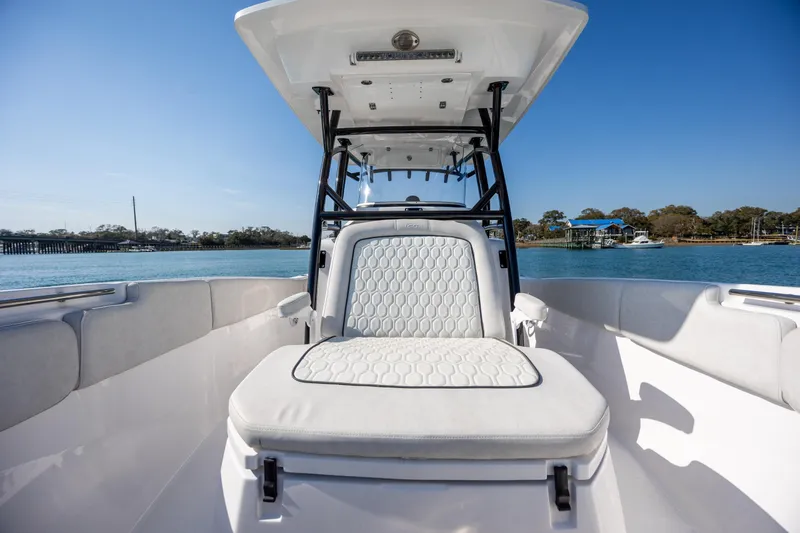 Slide: The Image of 2023 Sea Fox 288 Commander boat interior with cushioned seating, on a sunny day by the water. - 27
