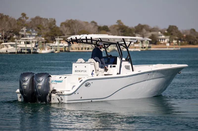 Slide: The Image of 2023 Sea Fox 288 Commander boat cruising on a calm lake with dual engines. - 5