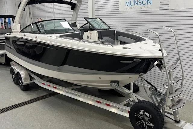 Slide: The Image of 2026 Chaparral SSX 8 boat on trailer in showroom, sleek black and white design. - 16