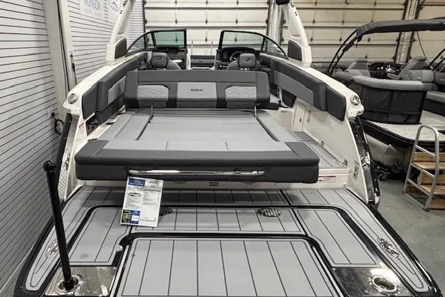 Slide: The Image of 2026 Chaparral SSX 8 boat interior with sleek seating and modern design in a showroom. - 20