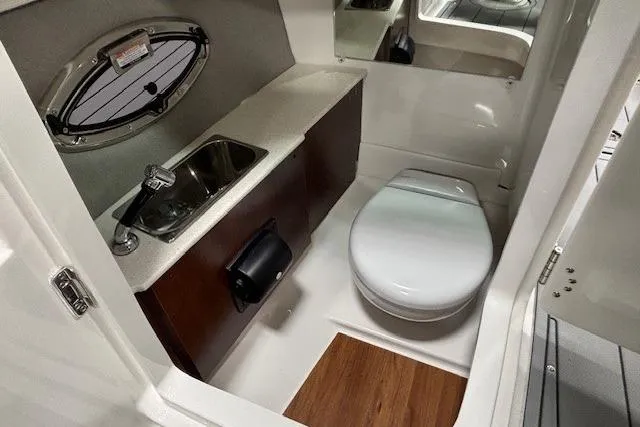 Slide: The Image of 2026 Chaparral SSX 8 boat interior with compact bathroom, featuring sink and toilet. - 23