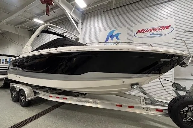 Slide: The Image of 2026 Chaparral SSX 8 boat on trailer in showroom, featuring sleek black and white design. - 35