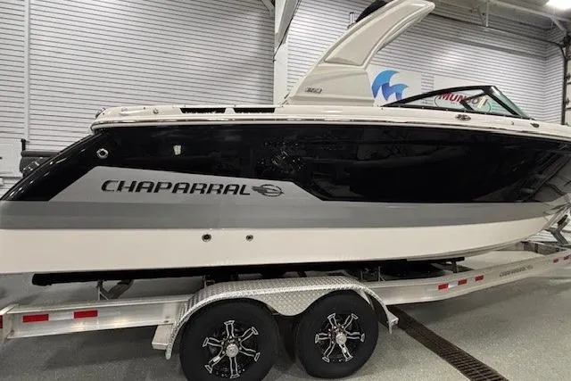 Slide: The Image of 2026 Chaparral SSX 8 boat on trailer in showroom, sleek black and white design. - 36