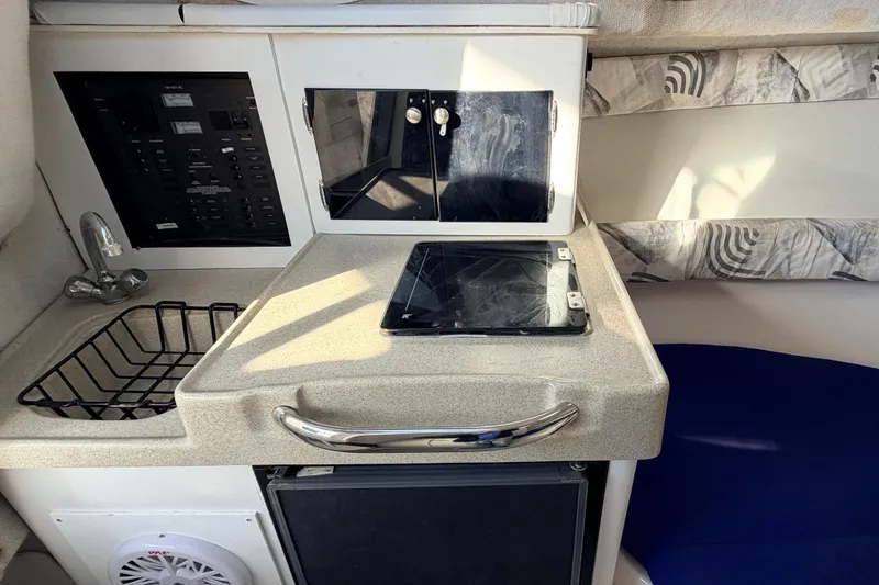 Slide: The Image of Interior of 2000 Wellcraft 270 Coastal O/B boat with kitchenette and control panel. - 18