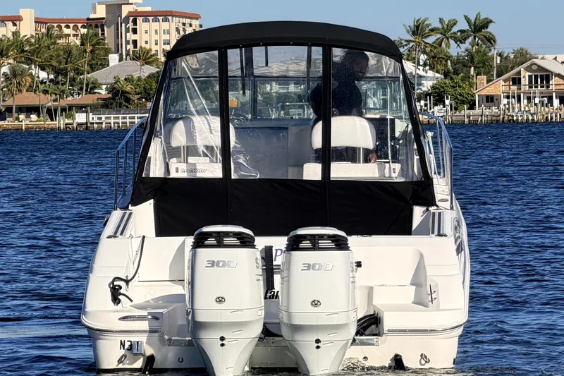 Slide: The Image of 2000 Wellcraft 270 Coastal O/B boat on water, dual engines, coastal background. - 2