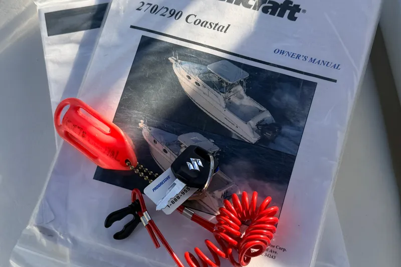 Slide: The Image of Owner's manual for 2000 Wellcraft 270 Coastal O/B with red safety lanyard. - 21