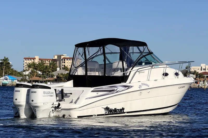 Slide: The Image of 2000 Wellcraft 270 Coastal O/B boat with twin Suzuki engines on the water. - 6
