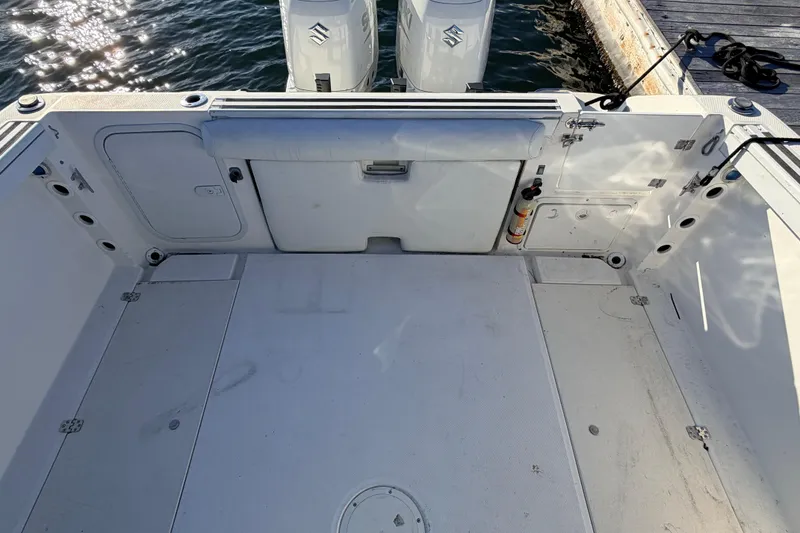 Slide: The Image of 2000 Wellcraft 270 Coastal O/B boat deck with dual outboard motors, docked by the water. - 9