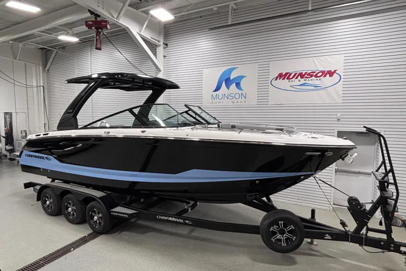 Slide: The Image of 2026 Chaparral SSX 30 boat on trailer in showroom, Munson Ski & Marine banners. - 14
