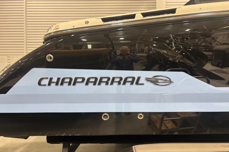 Slide: The Image of 2026 Chaparral SSX 30 boat with sleek black and white design in showroom. - 18