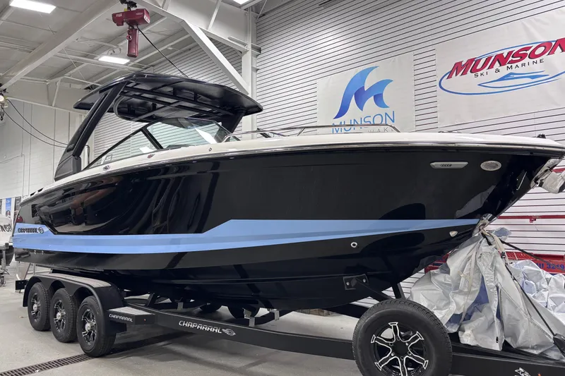 Slide: The Image of 2026 Chaparral SSX 30 boat in showroom, black with blue stripe, on trailer. - 7