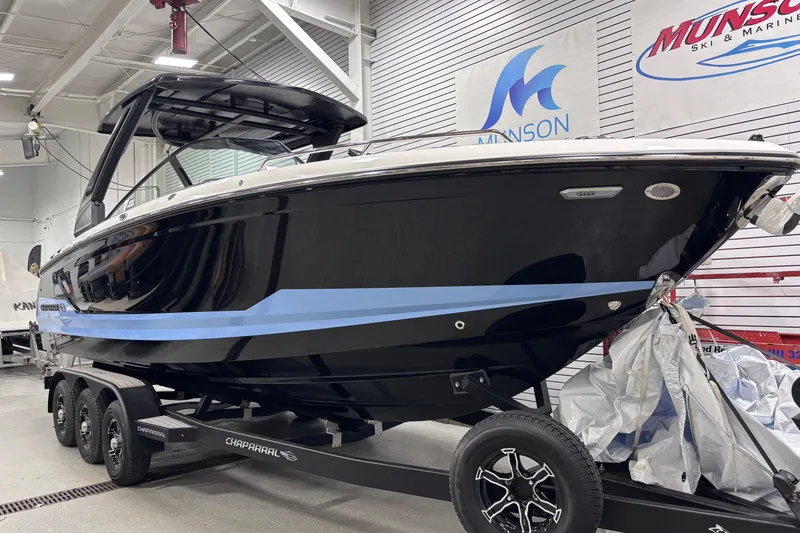 Slide: The Image of 2026 Chaparral SSX 30 boat on trailer in showroom, sleek black design. - 8