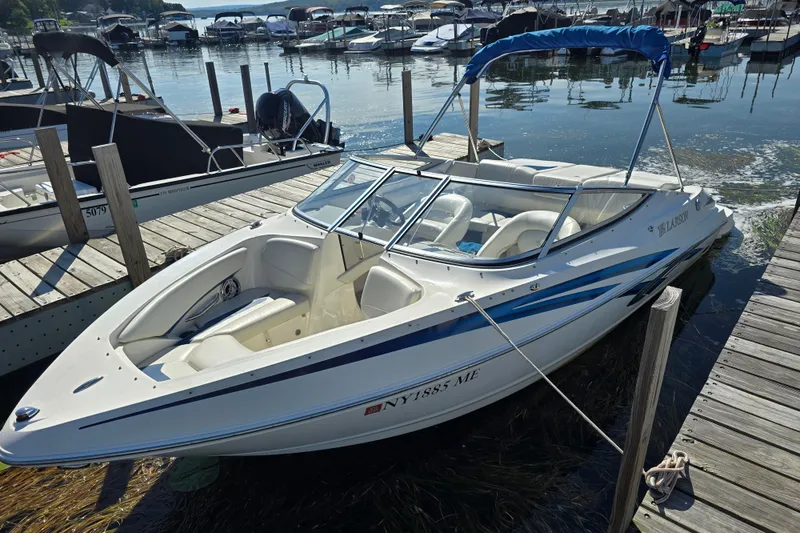 The Image of 2008 Larson Senza 186 boat docked at a marina, featuring sleek design and blue accents. - 5