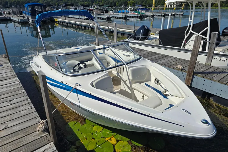 Slide: The Image of 2008 Larson Senza 186 boat docked at a marina, featuring sleek white and blue design. - 6