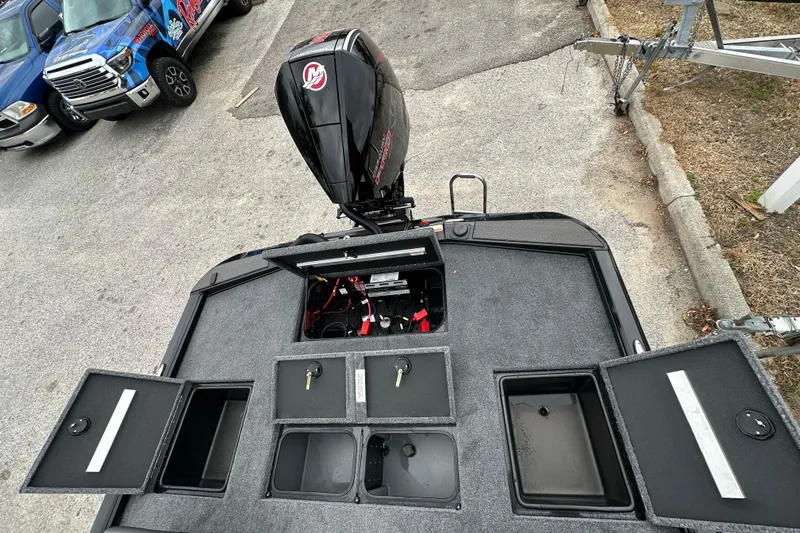 Slide: The Image of 2026 Ranger ALPHA 208 boat with open storage compartments and outboard motor. - 24