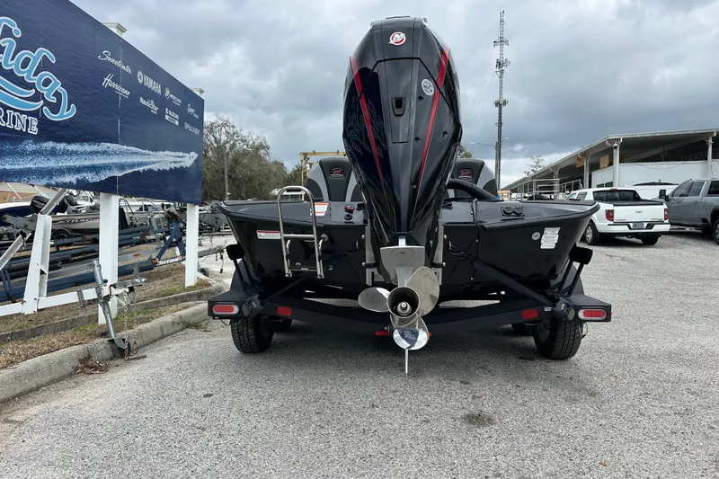 Slide: The Image of 2026 Ranger ALPHA 208 boat on trailer, rear view, parked near marine dealership. - 32