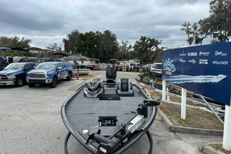 Slide: The Image of 2026 Ranger ALPHA 208 boat displayed at a dealership with trucks and boats in the background. - 6