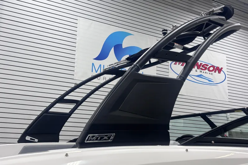 Slide: The Image of 2026 Chaparral 23 SSi boat with sleek black tower, displayed indoors. - 30