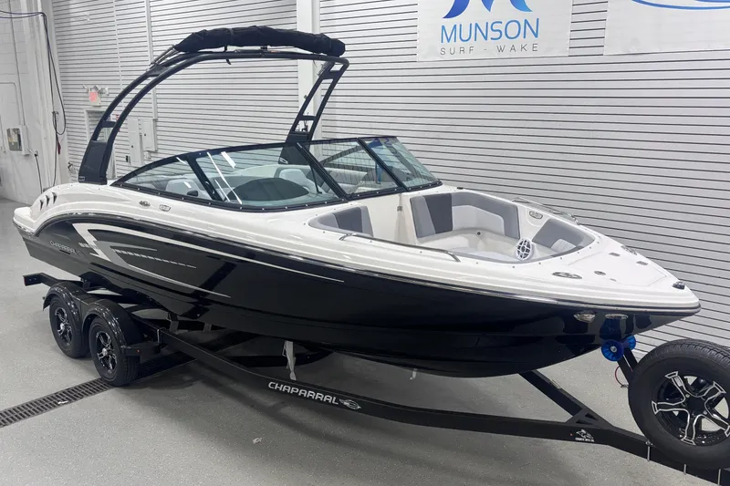 Slide: The Image of 2026 Chaparral 23 SSi boat in showroom, black and white design, on trailer. - 7