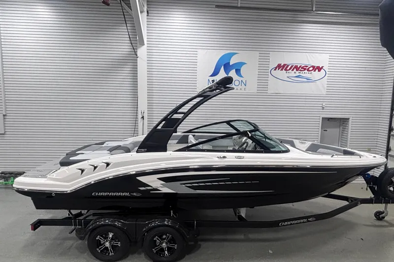 Slide: The Image of 2026 Chaparral 23 SSi boat in showroom, sleek design, black and white color scheme. - 0