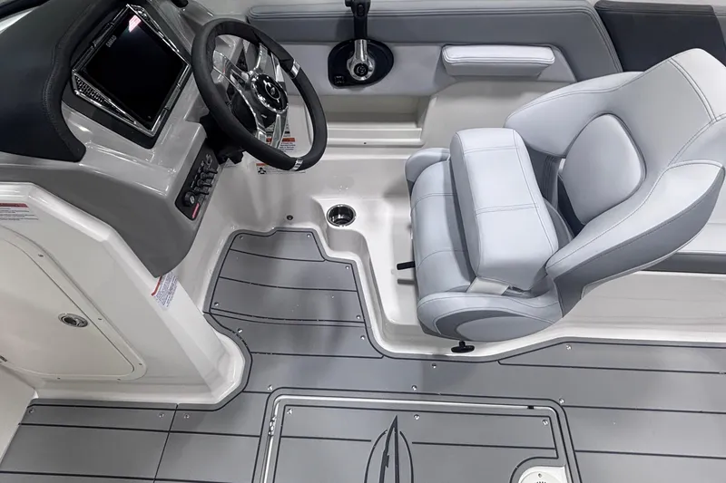Slide: The Image of 2026 Chaparral 23 SSi boat interior with steering wheel and gray seating. - 27