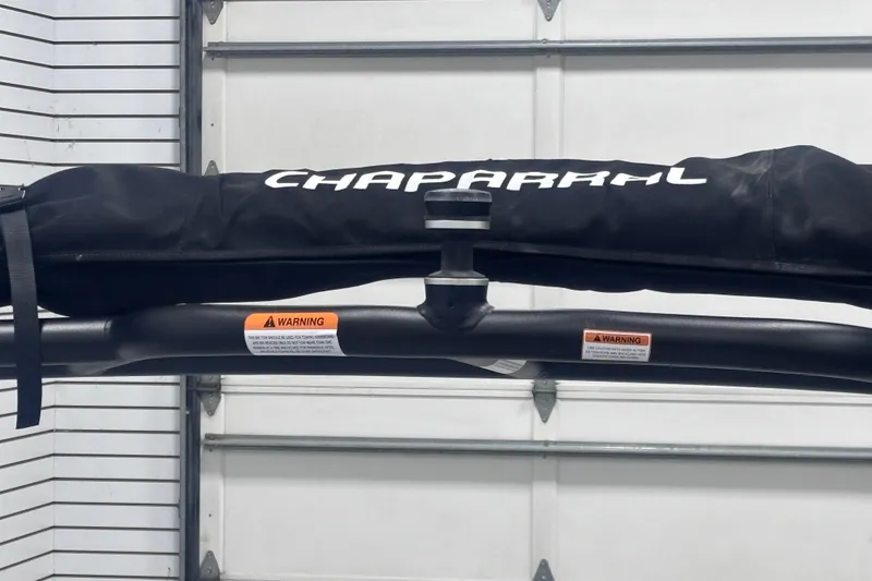 Slide: The Image of 2026 Chaparral 23 SSi boat cover with warning labels in a garage setting. - 29