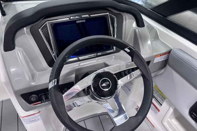 Slide: The Image of 2026 Chaparral 23 SSi boat dashboard with steering wheel and Simrad display. - 16