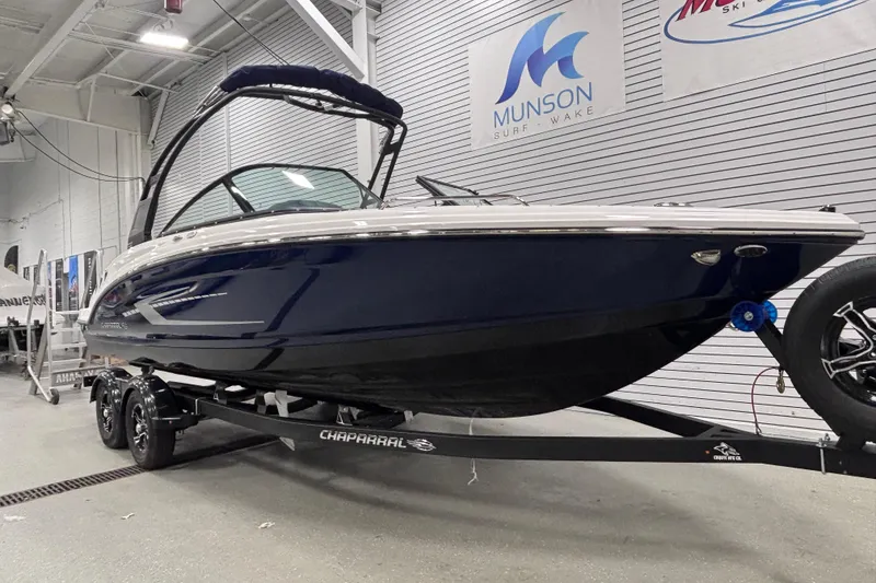 Slide: The Image of 2026 Chaparral 23 SSi boat on trailer in showroom, sleek design, Munson Surf & Wake. - 2