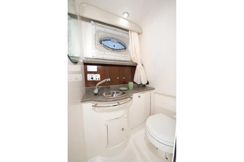 Slide: The Image of Manufacturer Provided Image: 2015 Robalo R305 Walkaround boat bathroom with sink, toilet, and porthole window. - 11