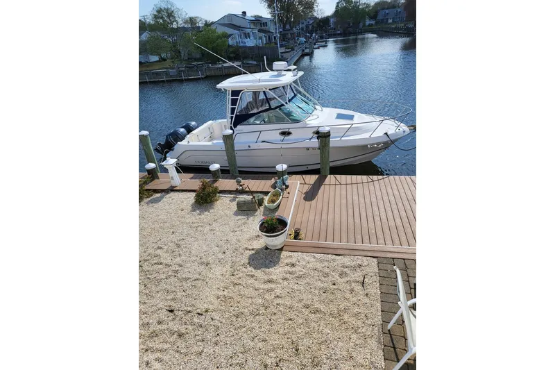 Slide: The Image of 2015 Robalo R305 Walkaround boat docked by a waterfront home. - 15