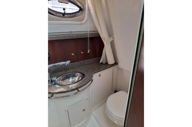 Slide: The Image of 2015 Robalo R305 Walkaround boat bathroom with sink, countertop, and toilet. - 24